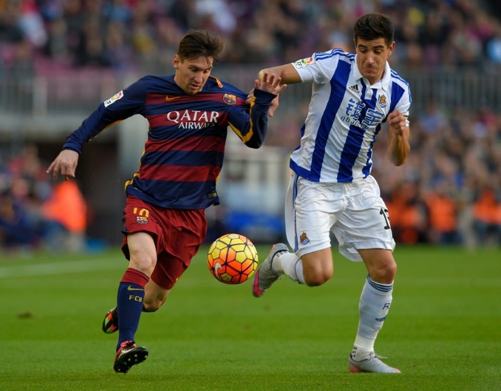 Yuri Berchiche lucha por un balón con Leo Messi. AFP