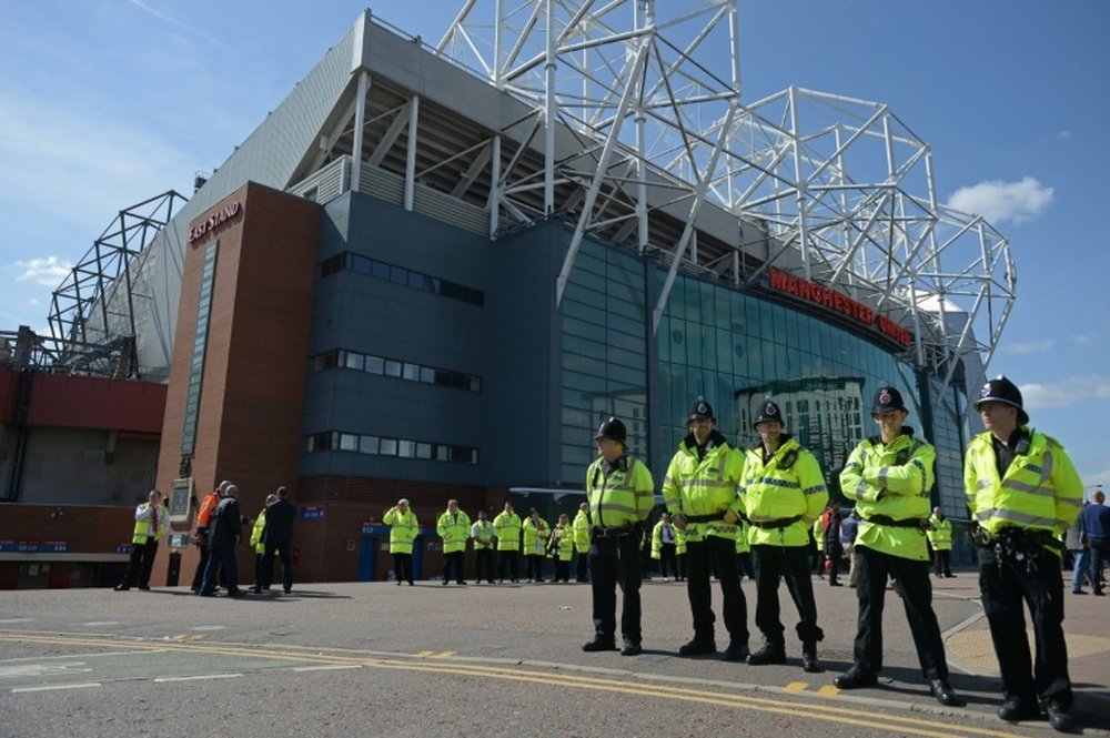 Police officers stand outside Old Trafford stadium in Manchester on May 15, 2016, after a bomb scare forced a Premier League football match between Manchester United and Bournemouth to be abandoned