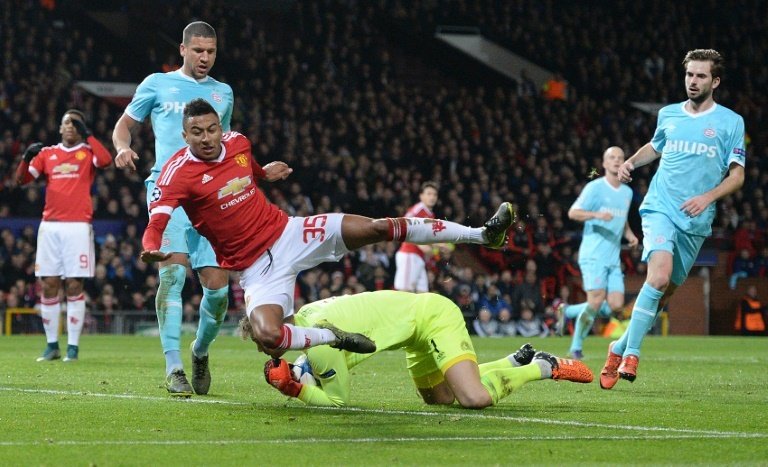 PSV Eindhovens goalkeeper Jeroen Zoet defends the ball from Manchester Uniteds midfielder Jesse Lingard (3rd L) during a UEFA Champions League match at Old Trafford Stadium on November 25, 2015