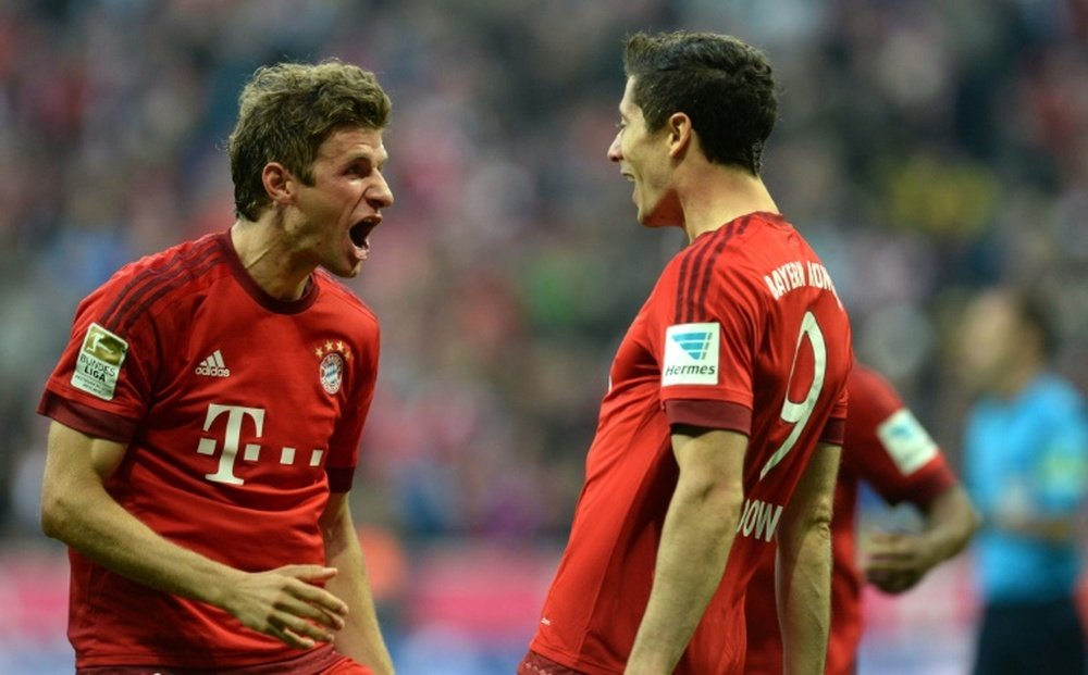 Bayern Munichs strikers Robert Lewandowski (R) and Thomas Mueller celebrate after the second goal for Munich during a German first division Bundesliga football match against Borussia Dortmund in Munich, southern Germany, on October 4, 2015