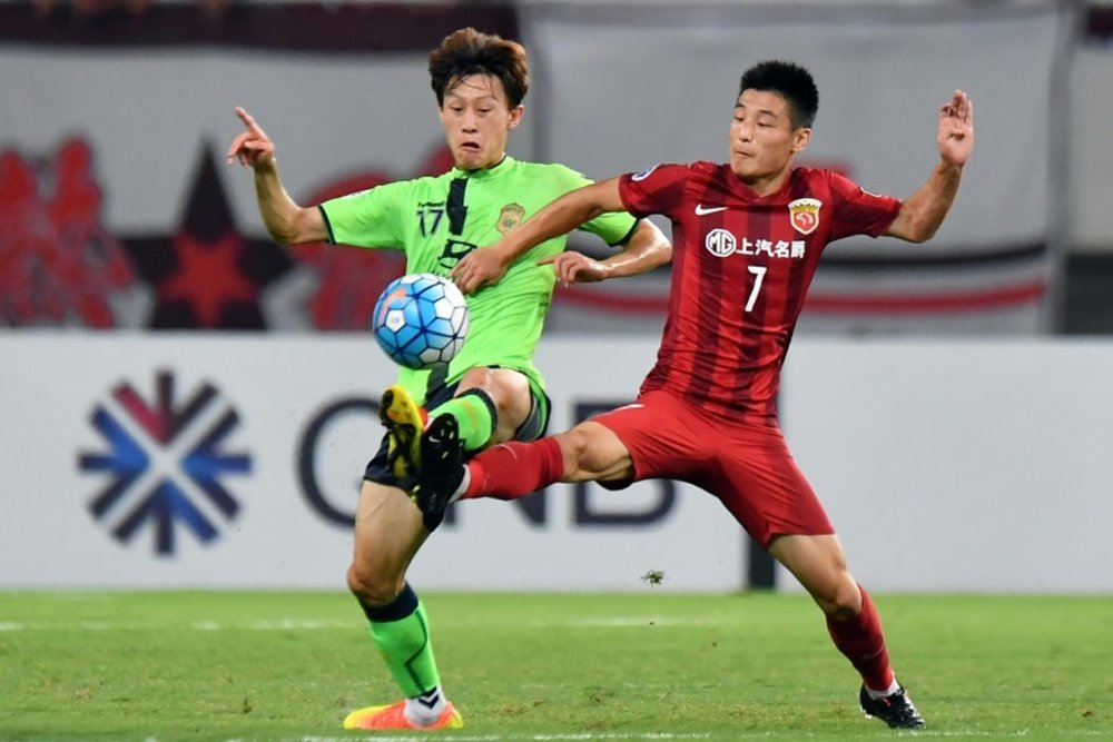 Wu Lei (R) of Chinas Shanghai SIPG fights for the ball with Lee Jae Sung of South Koreas Jeonbuk Hyundai Motors during their AFC Champions League quarter-final match, in Shanghai, on August 23, 2016