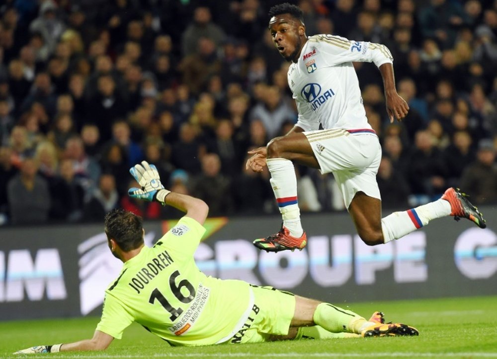 Lyons forward Maxwell Cornet (R) runs to score a goal past Montpelliers goalkeeper Geoffrey Jourdren on April 8, 2016 at the Mosson stadium in Montpellier, France