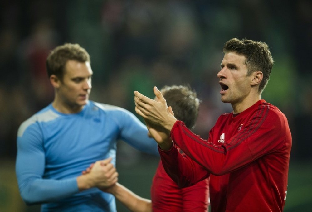 Bayern Munichs Thomas Mueller (R) acknowledges the fans at the end of their German Cup DFB Pokal 2nd round match against Wolfsburg, in Wolfsburg, on October 27, 2015