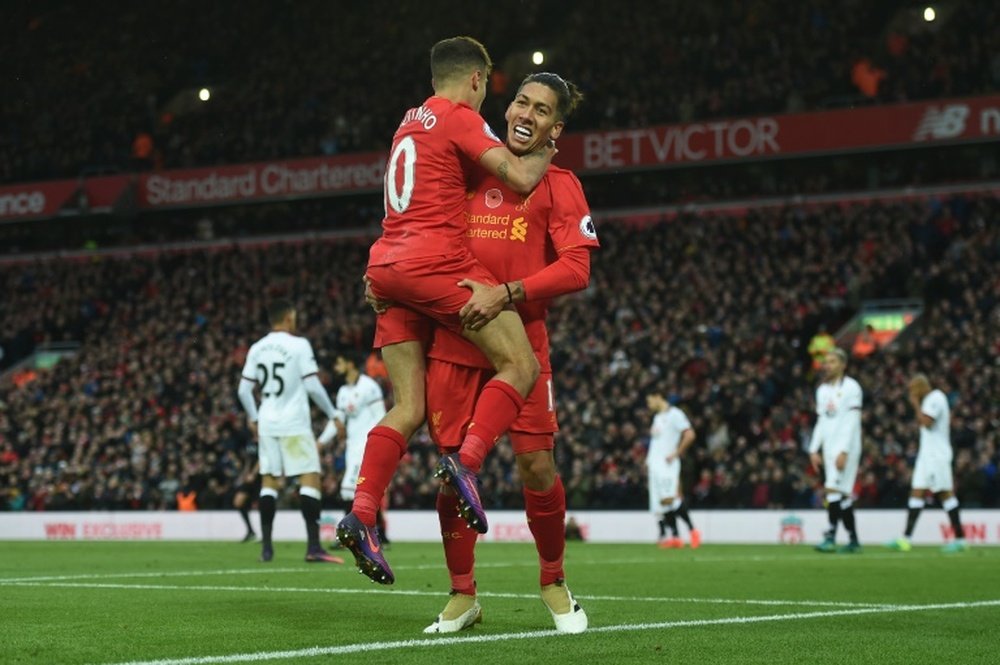 Firmino (R) celebrates a goal with Philippe Coutinho. AFP