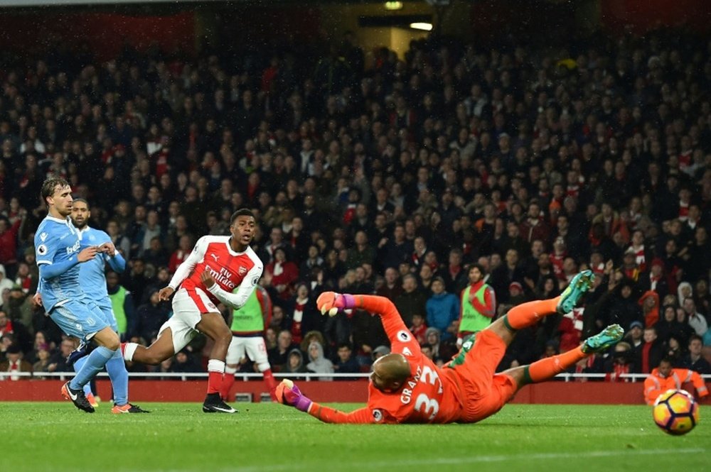 Arsenals Alex Iwobi (3L) shoots and scores past Stoke Citys goalkeeper Lee Grant at the Emirates Stadium in London