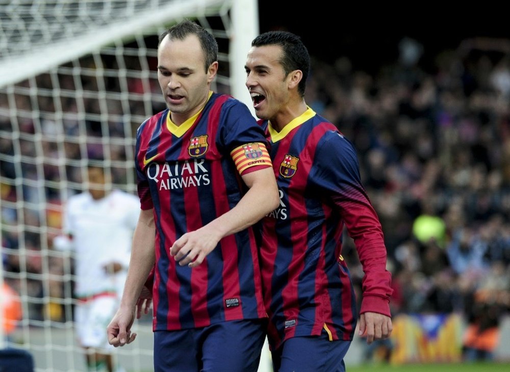 Barcelonas forward Pedro Rodriguez (R) congratulates midfielder Andres Iniesta on scoring at the Camp Nou stadium in Barcelona on November 23, 2013