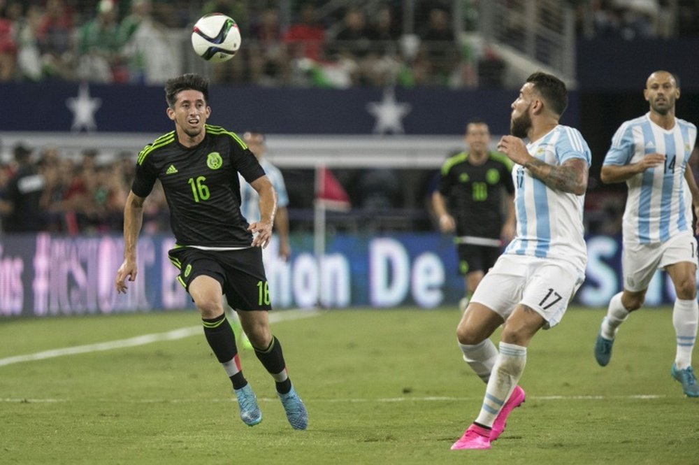 Hector Herrera (L) of Mexico and Nicolas Otamendi of Argentina chase a high ball during a international friendly at AT&T Stadium in Arlington, Texas on September 8, 2015