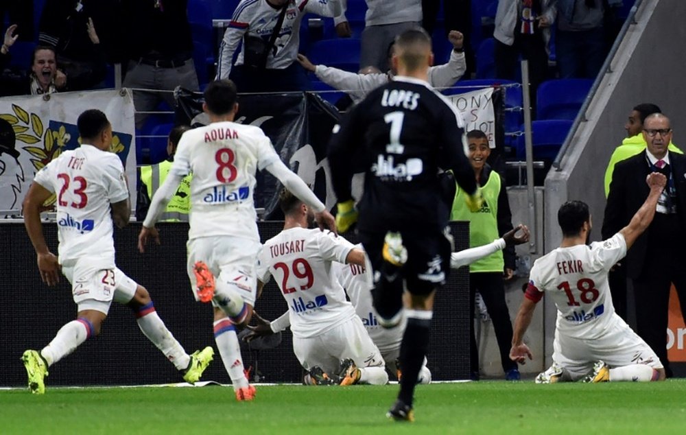 Lyons French forward Nabil Fekir (R) celebrates with teammates after scoring a goal