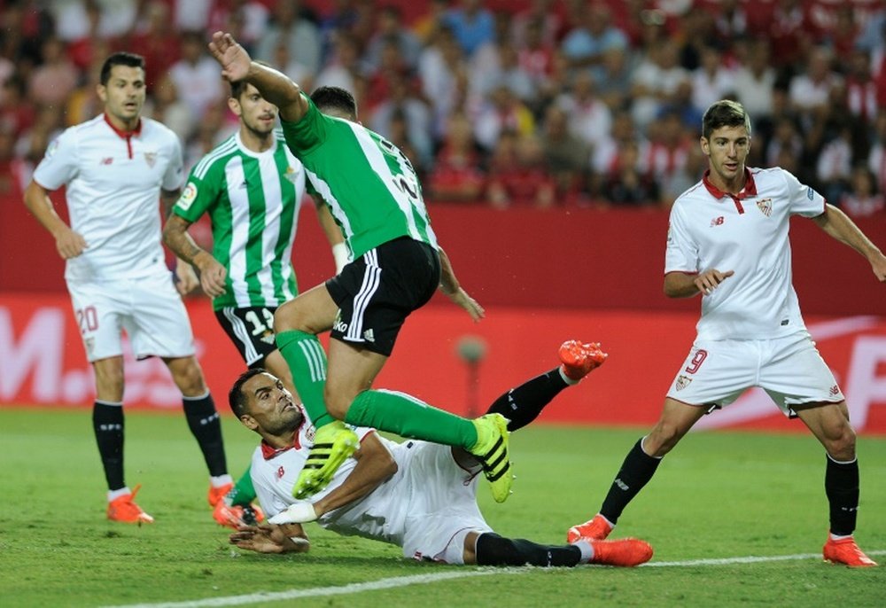 Sevillas Argentinian defender Gabriel Mercado (down) falls as he scores a goal during the Spanish league football match Sevilla FC vs Real Betis at the Ramon Sanchez Pizjuan stadium in Sevilla