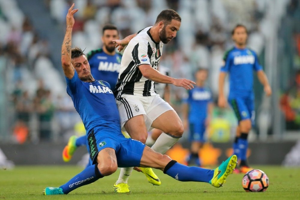 Juventus forward Gonzalo Higuain from Argentina (R) fights for the ball with Sassuolos defender Francesco Acerbi during the Italian Serie A football match Juventus Vs Sassuolo on September 10, 2016