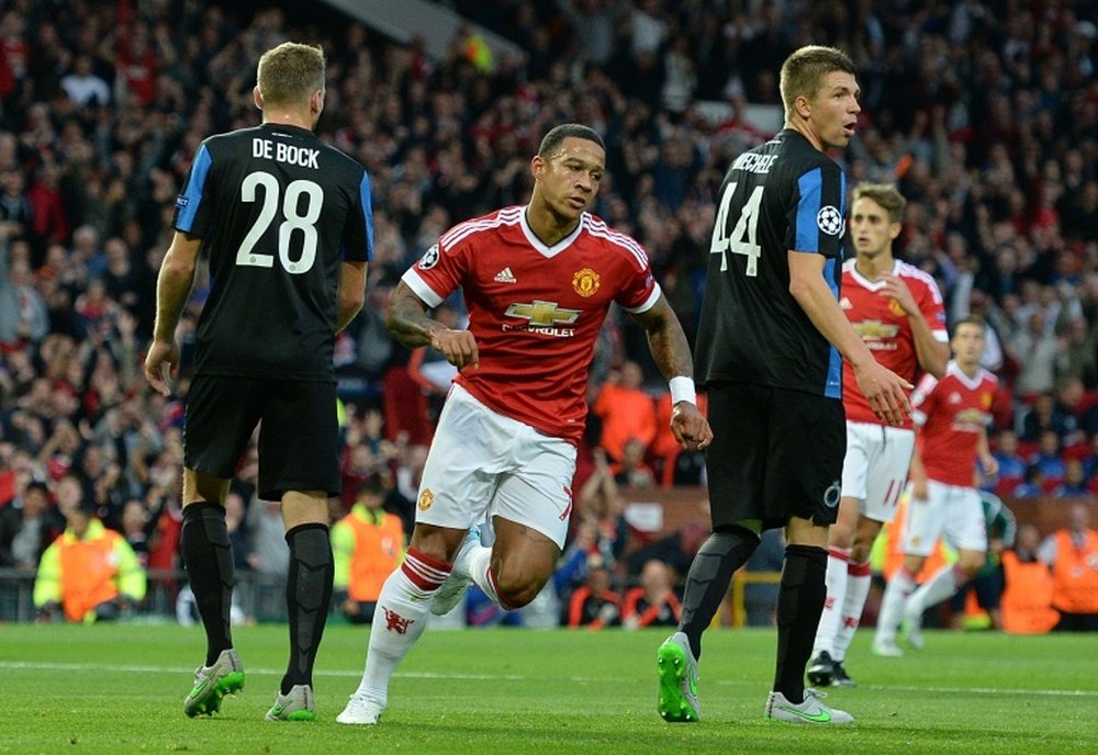 Manchester Uniteds midfielder Memphis Depay (2-L) wheels away in celebration after scoring his teams first goal during the UEFA Champions League play off against Club Brugge at Old Trafford on August 18, 2015