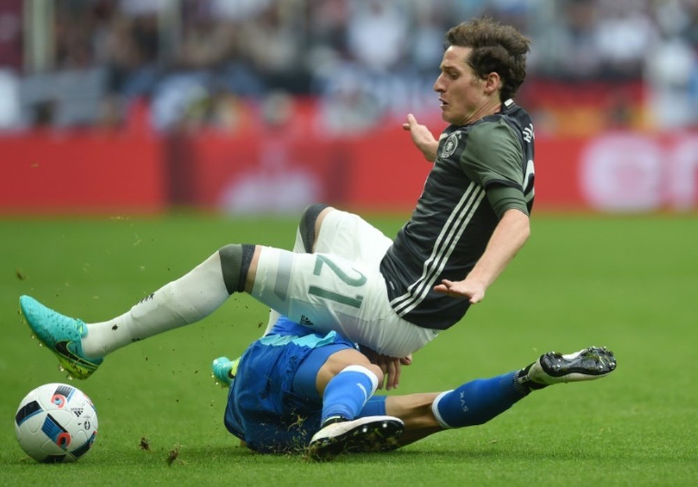 Germanys defender Sebastian Rudy (front) is tackled by Slovakian midfielder Vladimir Weiss. BeSoccer