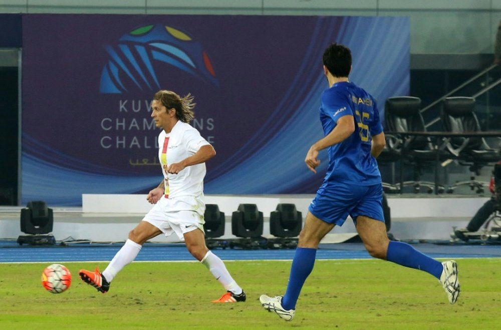 Spanish footballer Michel Salgado (L) passes the ball ahead of Kuwaits Khaled Ibraheem (R) during a friendly ceremonial match between Kuwait all-stars team and Football Champions Tour Legends on December 18, 2015 in Kuwait City