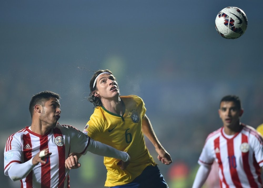 Filipe Luis (centre) jumps for the ball during Brazils Copa America quarter-final against Paraguay in Concepcion, Chile, on June 27, 2015