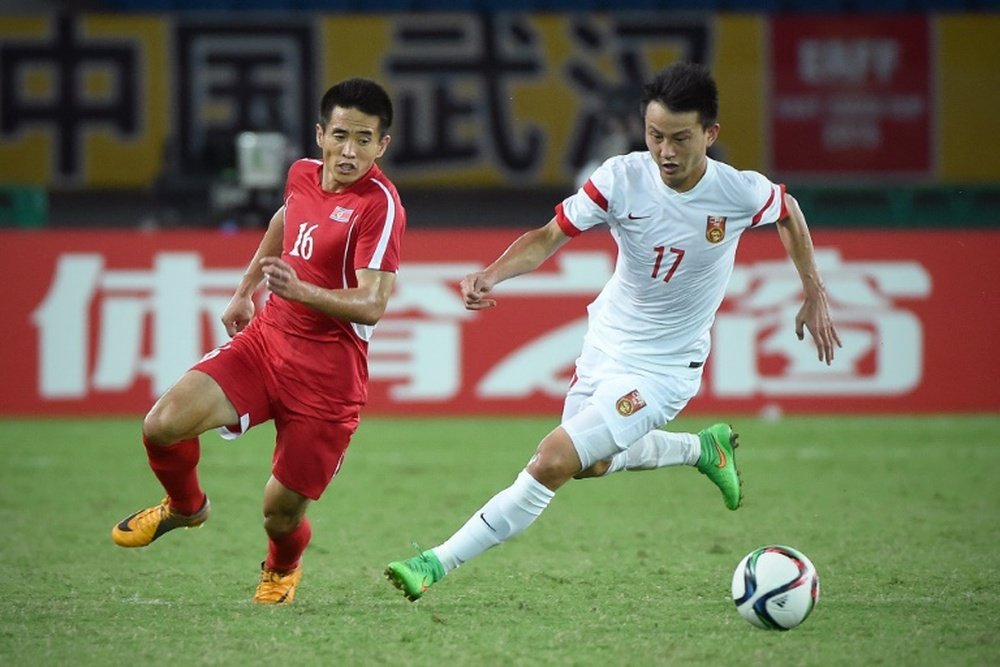 Chinas Rao Weihui (R) challenges North Koreas Ro Hak Su during the mens East Asian Cup football match in Wuhan on August 5, 2015