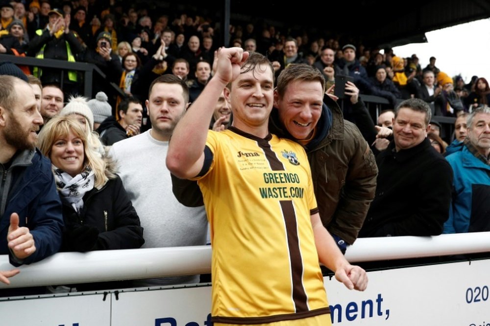 Sutton United's Jamie Collins celebrates with supporters. AFP