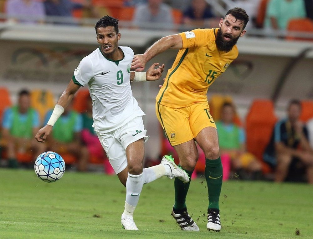 Australias Mile Jedinak (R) marks Saudi Arabias Nawaf Alabid during a 2018 FIFA World Cup qualifying match in Jeddah on October 6, 2016