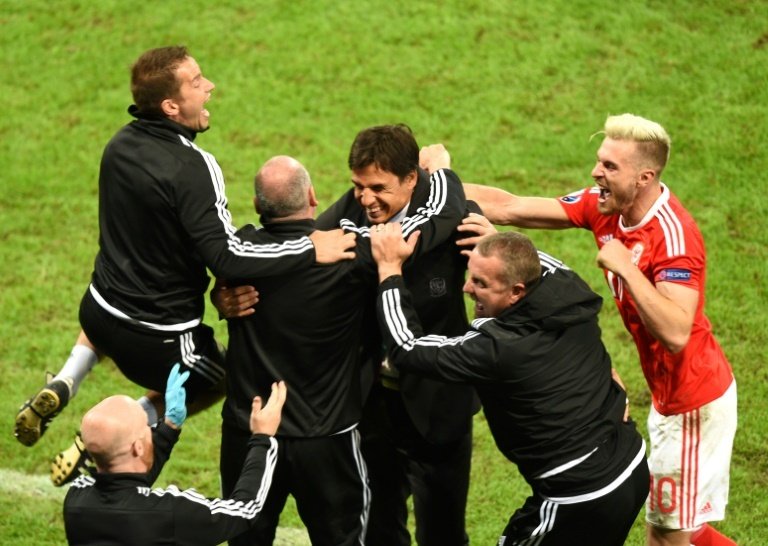 Wales coach Chris Coleman (C) and team staff celebrate at the end of their teams 3-1 victory in a Euro 2016 quarter-final against Belgium at the Pierre-Mauroy stadium in Villeneuve-dAscq near Lille, on July 1, 2016