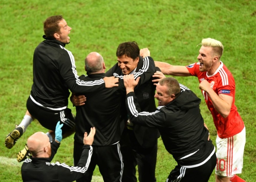 Wales coach Chris Coleman (C) and team staff celebrate at the end of their teams 3-1 victory in a Euro 2016 quarter-final against Belgium at the Pierre-Mauroy stadium in Villeneuve-dAscq near Lille, on July 1, 2016