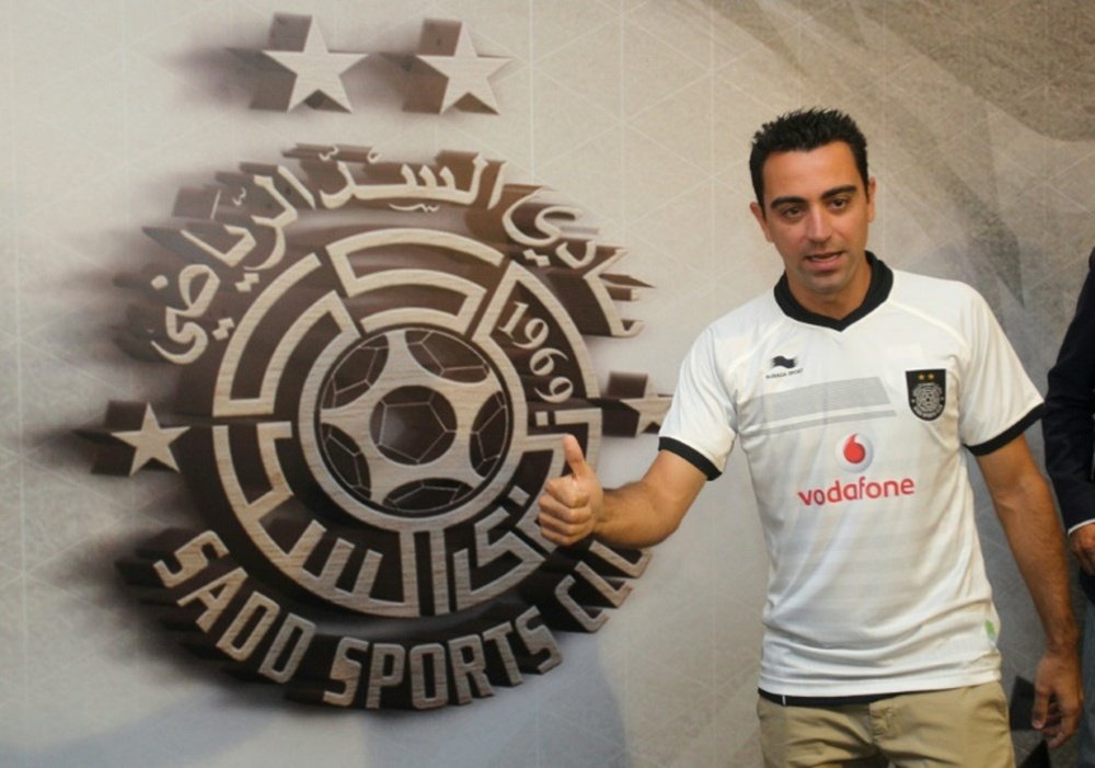 Barcelona legend Xavi Hernandez poses for a photo in his new Al-Sadd club shirt after signing a two-year contract with the Qatari team in Doha on June 11, 2015