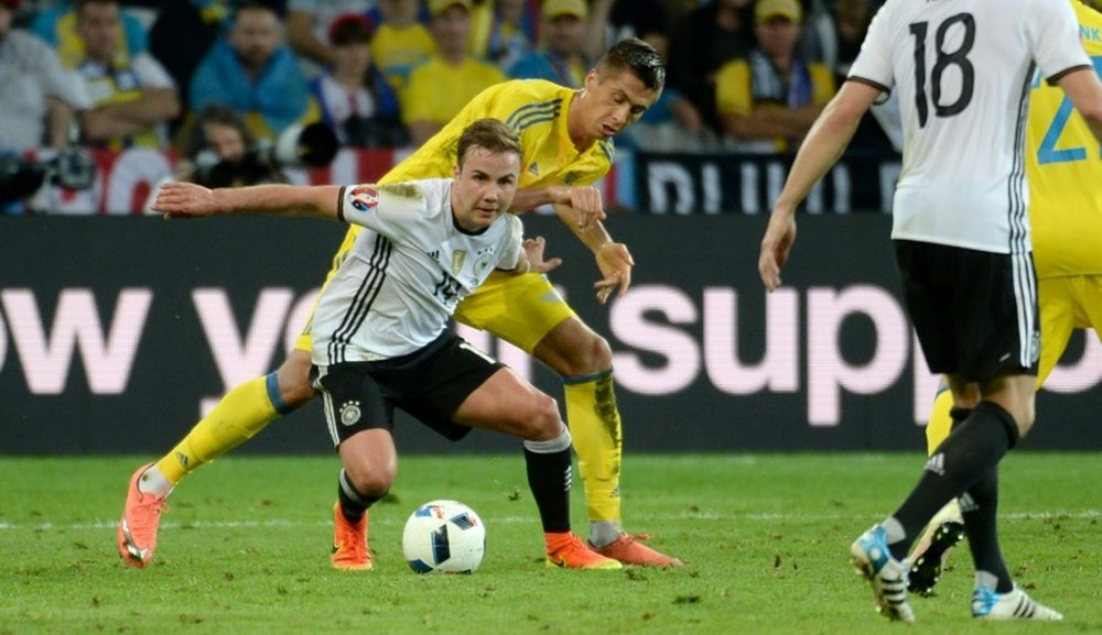 Germanys forward Mario Goetze (centre) vies with Ukraines defender Yevhen Khacheridi during their Euro 2016 match at the Stade Pierre Mauroy in Villeneuve-dAscq on June 12, 2016