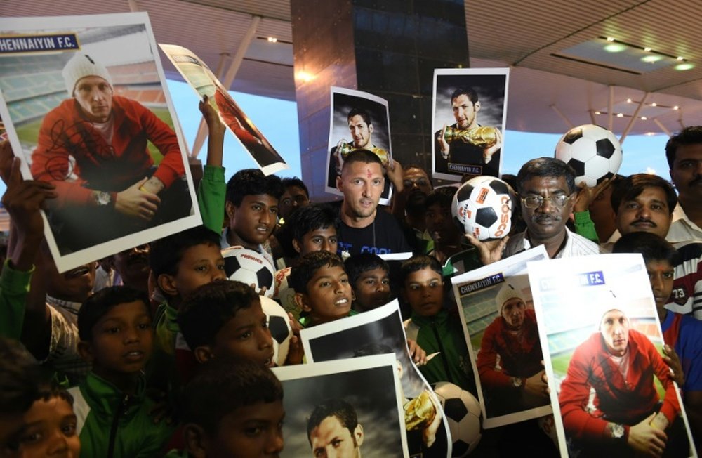 Italian footballer Marco Materazzi (top C) poses with football fans who had gathered at the Kempegowda International Airport to welcome him on his arrival in Bangalore on September 20, 2014