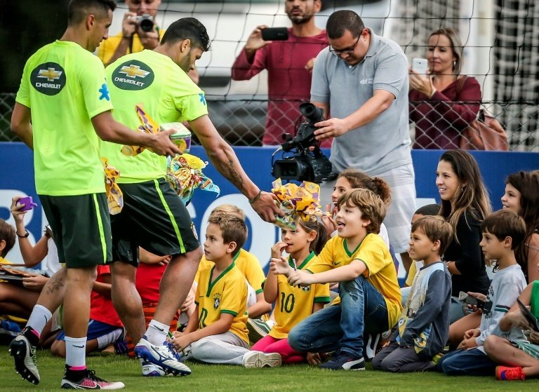 Brazils football players celebrate Easter with children following a training session. BeSoccer