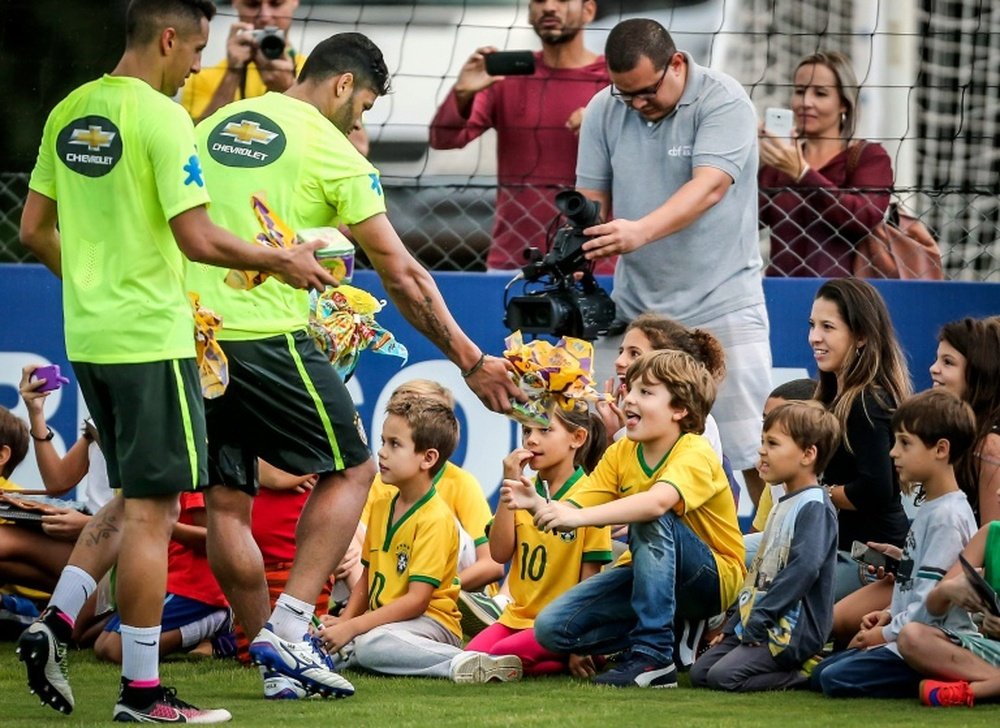 Brazils football players celebrate Easter with children following a training session. BeSoccer