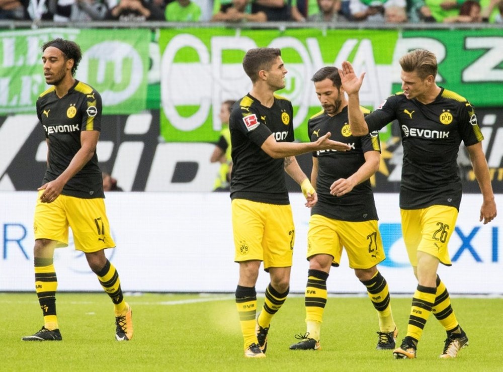 Dortmund players celebrate scoring the opening goal during the Bundesliga match against Wolfsburg