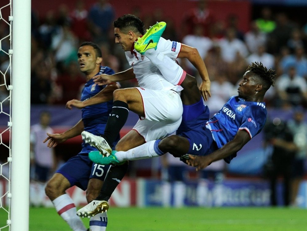 Sevilla forward Wissam Ben Yedder (C) scores a goal beside Lyons defender Yanga-Mbiwa. AFP