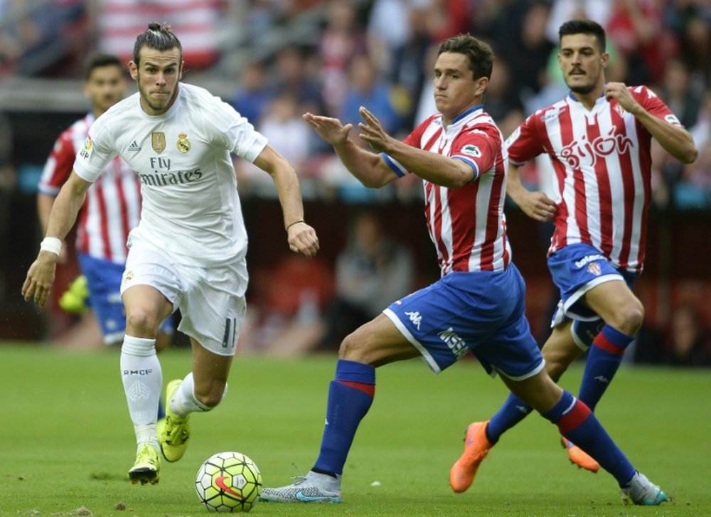 Real Madrids Gareth Bale (L) fights for the ball with Sporting Gijons Bernardo during their Spanish La Liga match, at the El Molinon stadium in Gijon, on August 23, 2015