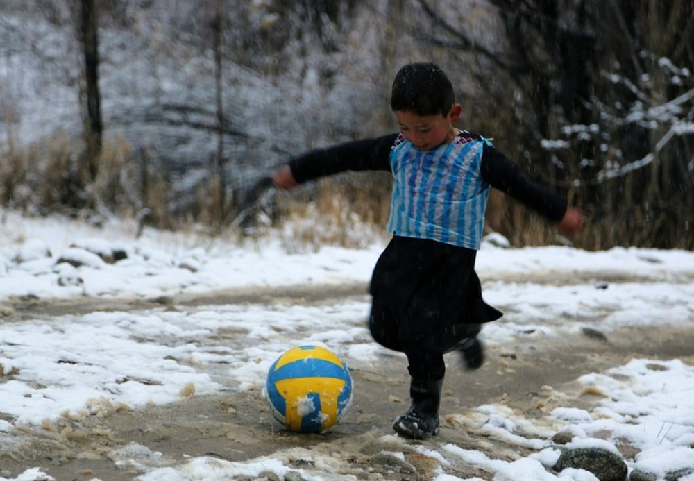 Afghan Lionel Messi fan Murtaza Ahmadi, 5, wears a plastic bag jersey as he plays football in Jaghori district of Ghazni province