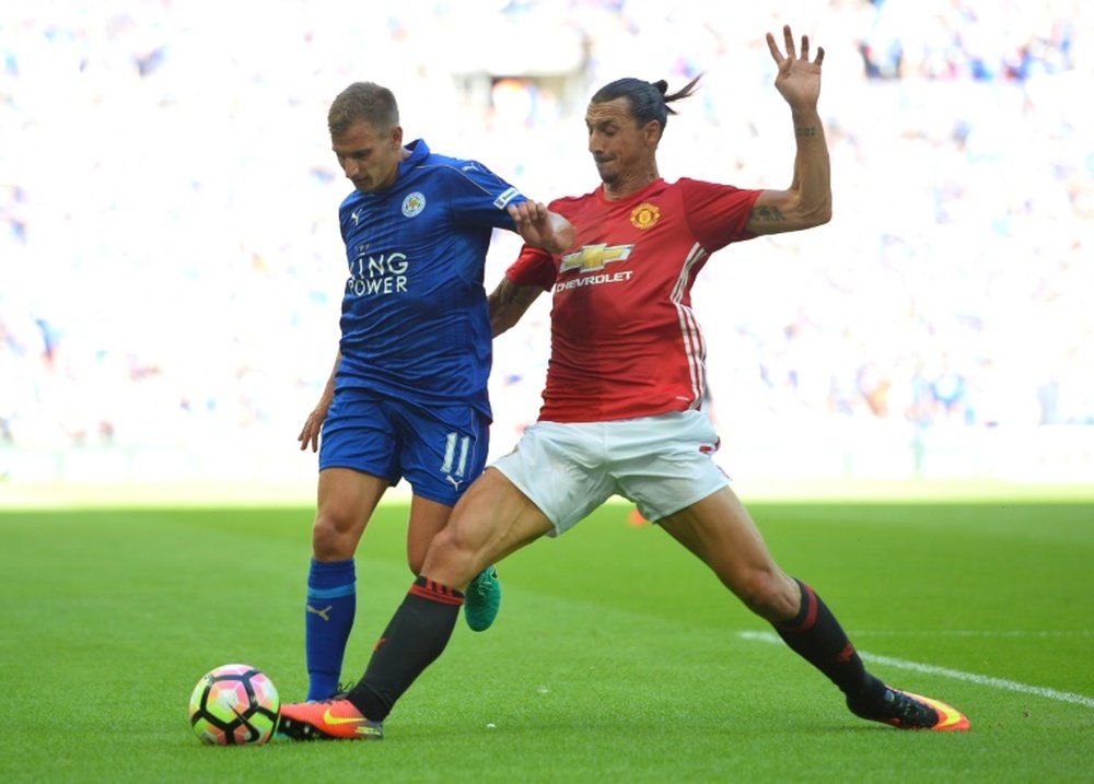 Zlatan Ibrahimovic (R) tackles Marc Albrighton (L) in the Community Shield. AFP