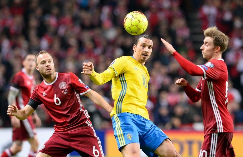 Swedens forward and team captain Zlatan Ibrahimovic vies with Denmarks defender Lars Jacobsen (L) during the Euro 2016 second leg play-off football match at Parken stadium in Copenhagen on November 17, 2015