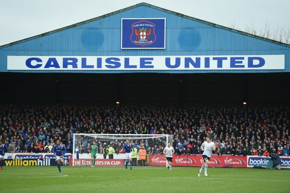 Fans line the terraces behind the goal during the English FA Cup fourth round football match between Carlisle United and Everton at Brunton Park, in Carlisle, north west England, on January 31, 2016