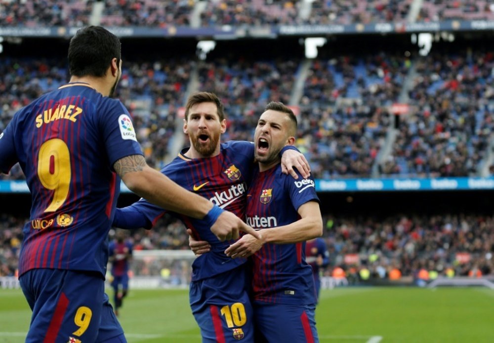 Barcelona's Luis Suarez (L) celebrates a goal with teammates Lionel Messi (C) and Jordi Alba during their match against RC Celta de Vigo at the Camp Nou stadium in Barcelona on December 2, 2017