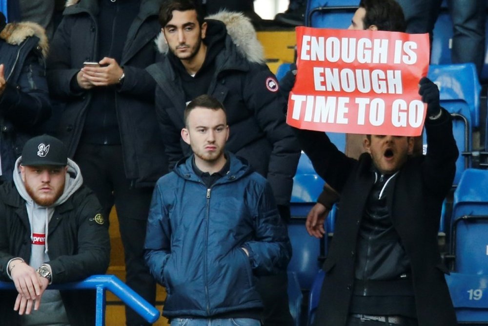 An Arsenal fan holds up a banner calling on manager Arsene Wenger to quit. AFP