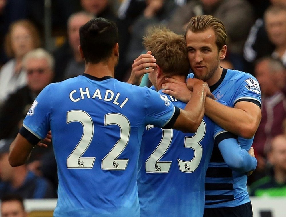 Tottenham Hotspurs Nacer Chadli (L) and Harry Kane (R) congratulate Christian Eriksen after he scored during an English Premier League football match against Swansea City at The Liberty Stadium in Swansea, south Wales on October 4, 2015