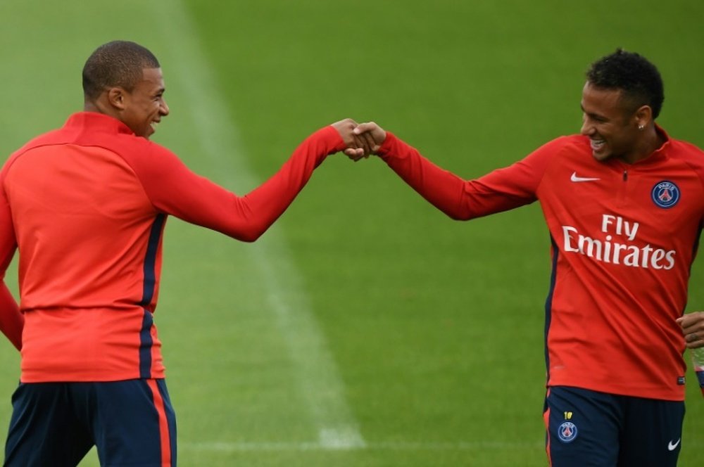 Paris Saint-Germain's Kylian Mbappe (L) and Neymar interact during a training session. AFP