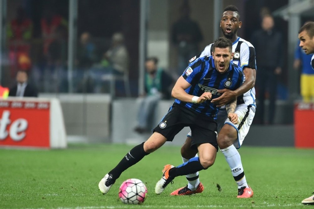 Inter Milans midfielder from Montenegro Stevan Jovetic (L) fights for the ball with Udineses defender from Mali Molla Wague during an Italian Serie A football match at the San Siro Stadium in Milan on April 23, 2016