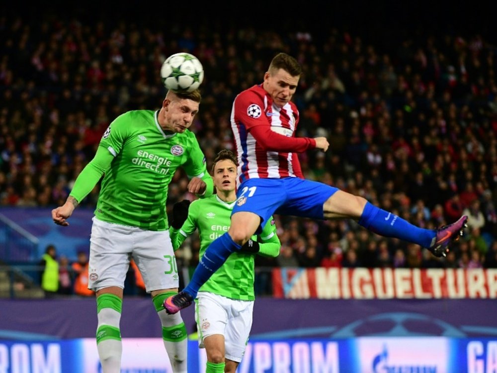 Atletico Madrid forward Kevin Gameiro (R) jumps for the ball against PSV Eindhoven. AFP