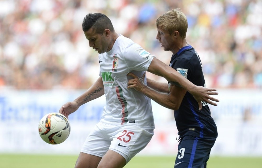 Augsburg striker Raul Bobadilla (R) and Hertha Berlin midfielder Per Cijan Skjelbred vie for the ball during their Bundesliga match in Augsburg on August 15, 2015