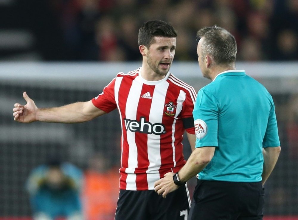 Southamptons striker Shane Long (L) talks with referee Jon Moss during an English Premier League football match against Arsenal on December 26, 2015