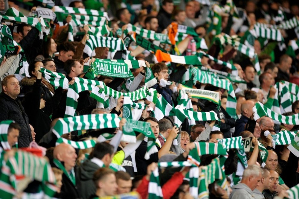 Celtic fans raise their scarves in the crowd at a match in Glasgow, Scotland on October 1, 2015