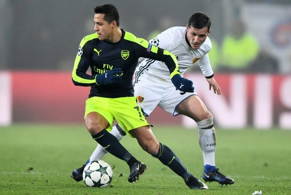 Arsenals forward Alexis Sanchez (L) vies with Basels midfielder Taulant Xhaka during the UEFA Champions league Group A football match December 6, 2016