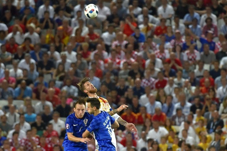 Spains defender Sergio Ramos (C) heads the ball ahead of Croatias midfielder Ivan Rakitic (L) and Croatias forward Nikola Kalinic during the Euro 2016 group D football match between Croatia and Spain in Bordeaux on June 21, 2016.