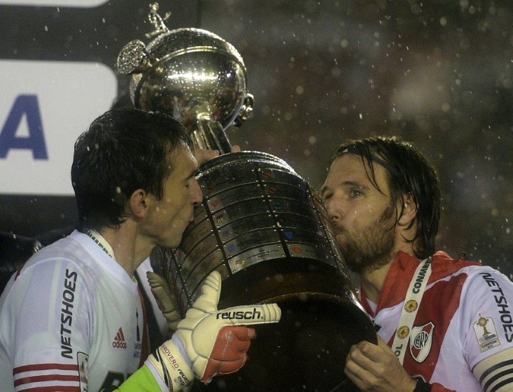 Barovero y Cavenaghi besan el trofeo de la copa Libertadores 2015. AFP