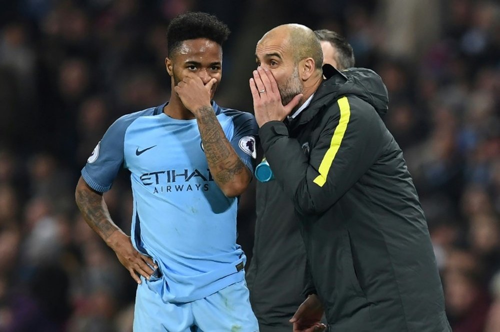 Manchester City manager Pep Guardiola (R) talks to midfielder Raheem Sterling. AFP