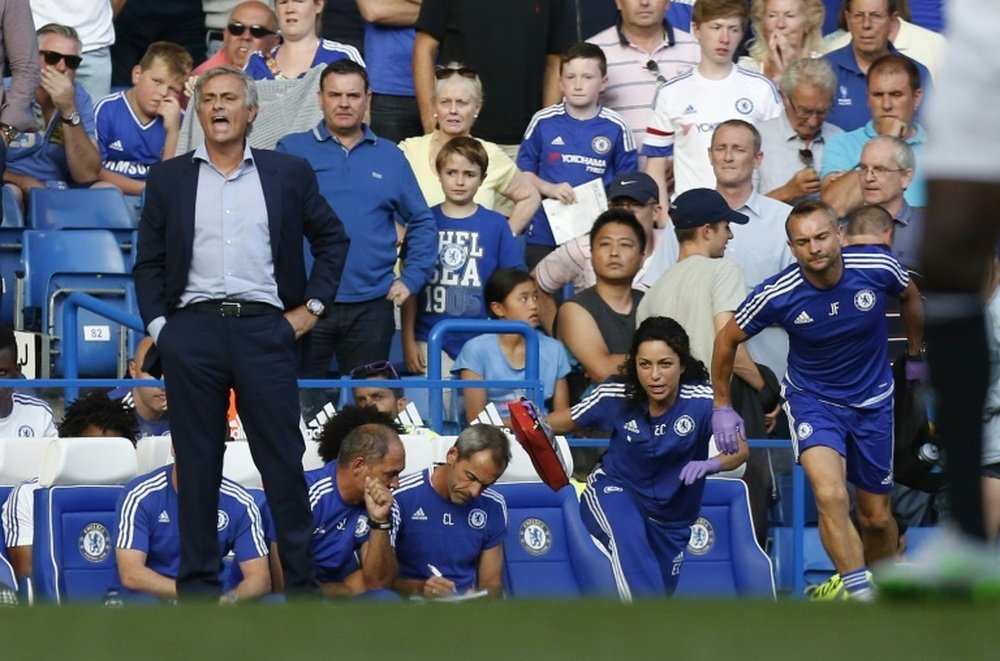 Chelsea doctor (2R) Eva Carneiro and head physio Jon Fearn (R) leave the bench to treat Eden Hazard as manager Jose Mourinho (L) gestures during the English Premier League football match between Chelsea and Swansea City in London on August 8, 2015