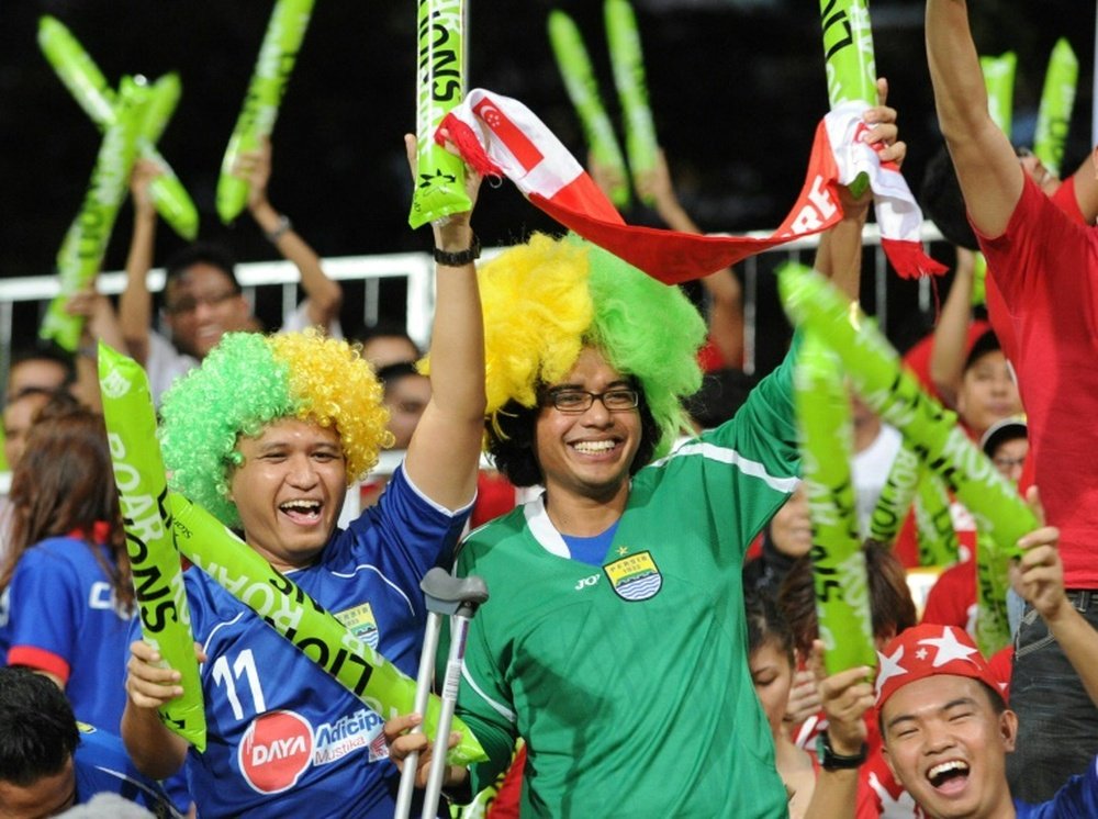 Supporters for the Lions XII team cheer during a football match in Singapore on January 10, 2012